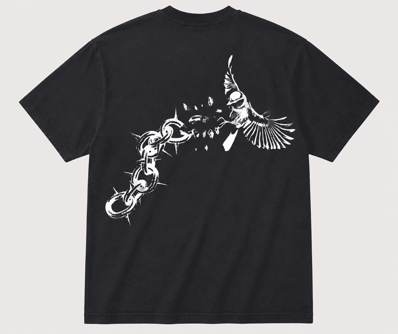 Back of the tee: spiked chain mid-shatter, one bird escaping toward the shoulder